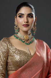 Woman wearing traditional jewelry and a saree against a dark background