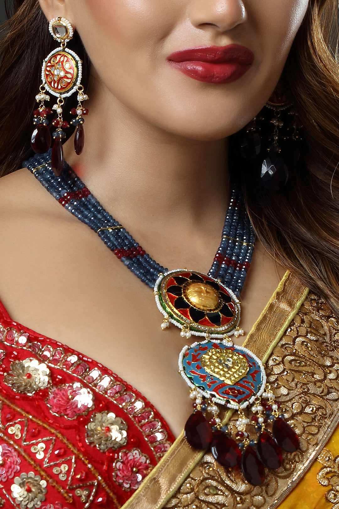 Close-up of a woman wearing traditional jewelry with a red and gold outfit.