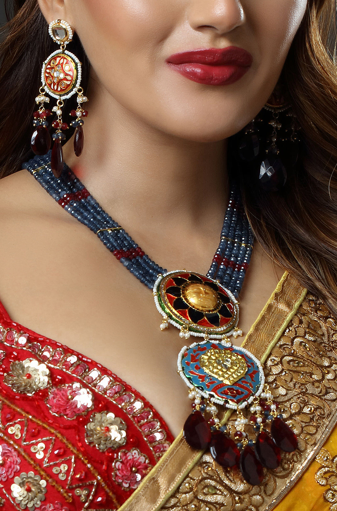 Close-up of a woman wearing traditional jewelry with a red and gold outfit.
