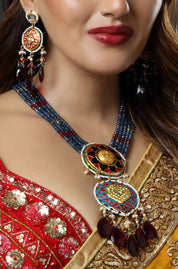 Close-up of a woman wearing traditional jewelry with a red and gold outfit.