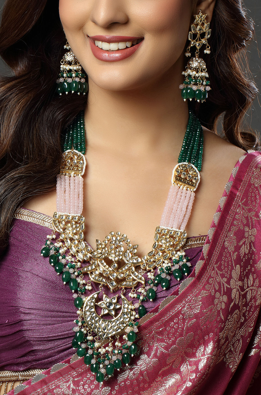 Woman wearing a traditional saree with jewelry, including a necklace and earrings.